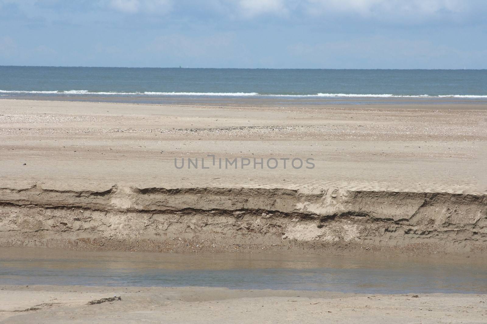 Waves with white crests inundate the sand beach