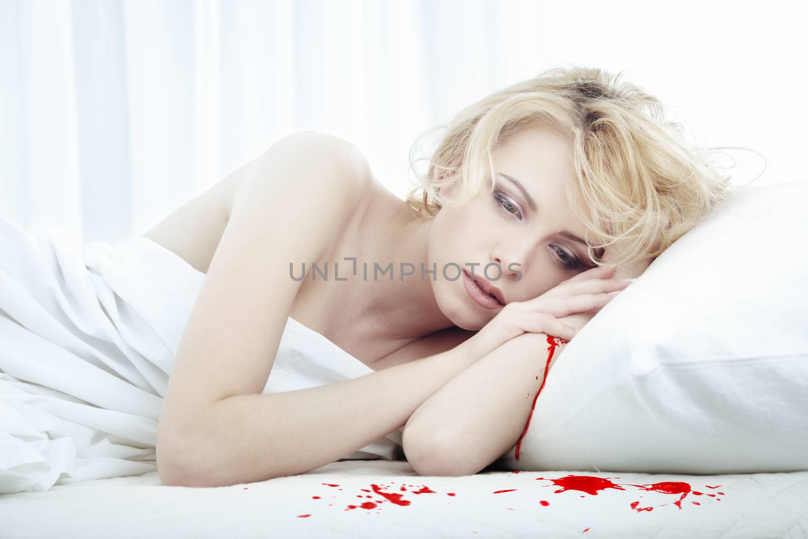 Bleeding beautiful sad woman laying on the bed