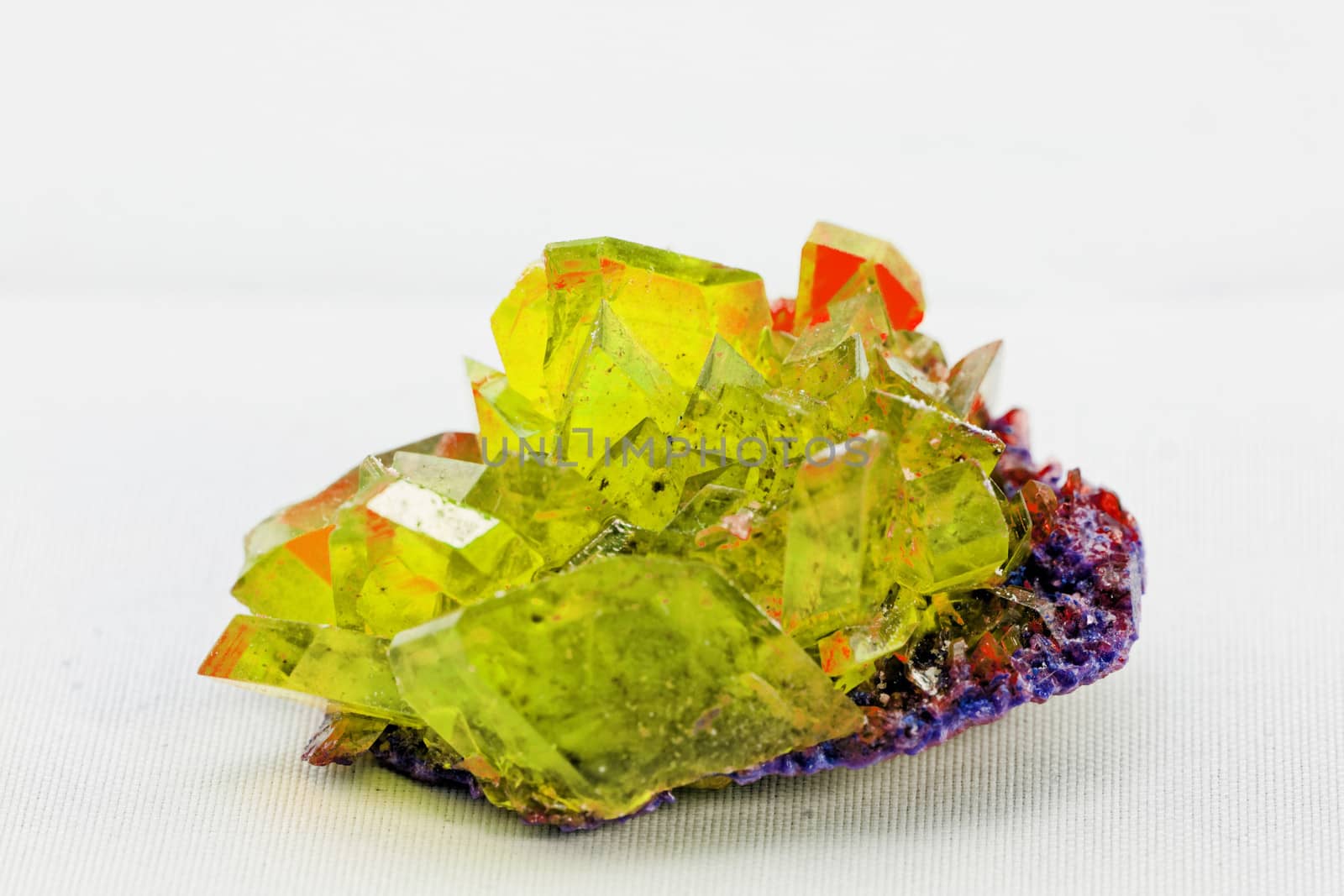 Close up picture about a crystal with topaz color on white background (yellow crystal)