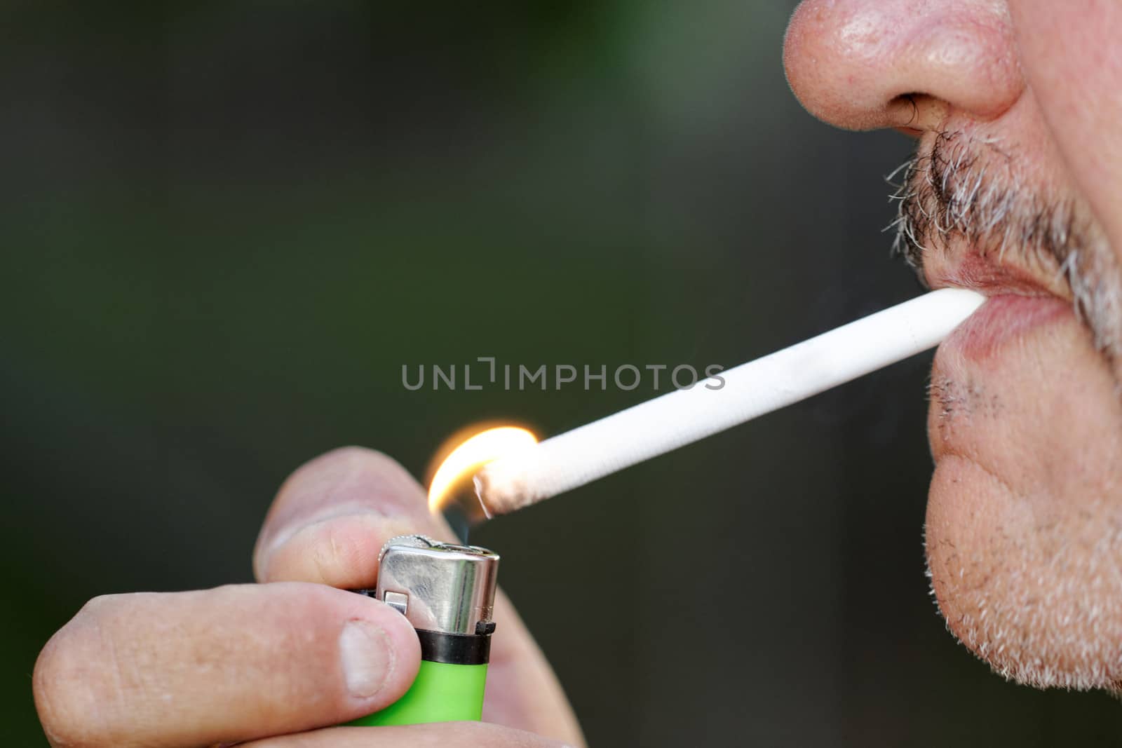 Smoking a cigarette against a dark background