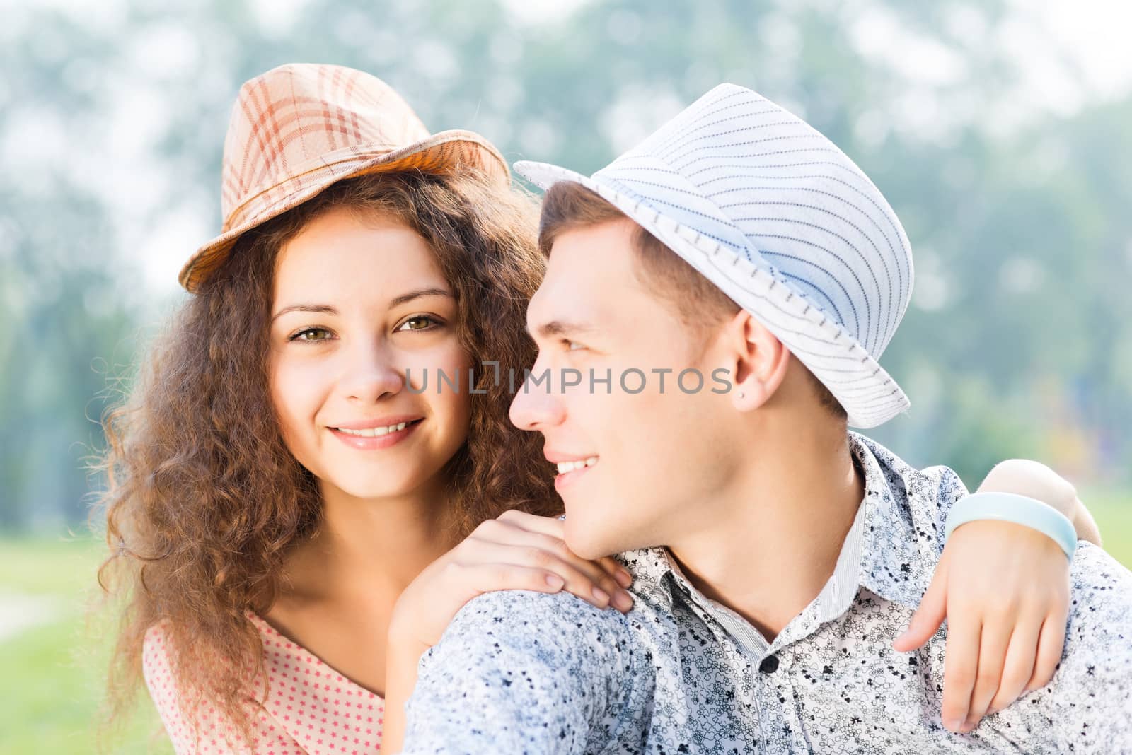 romantic couple lying on the grass in the summer park, spending time with loved ones