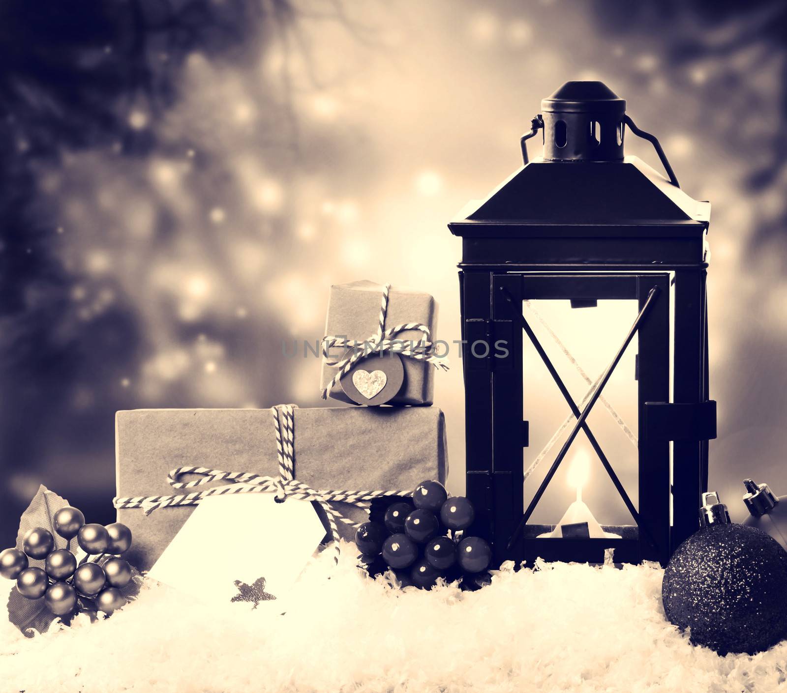 Christmas lantern with presents, ornaments and snow in sepia tone