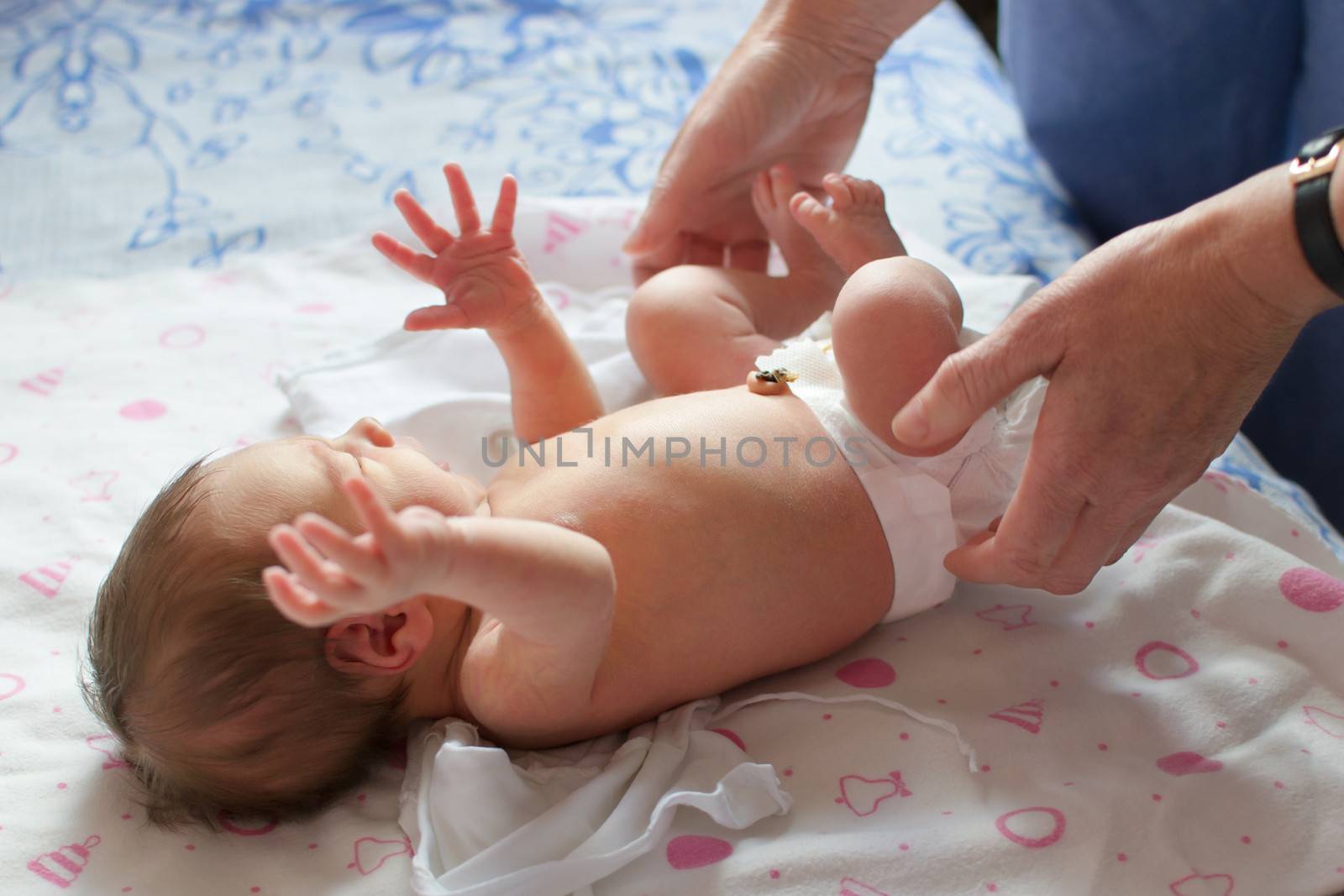 A newborn (1 week old) baby being examined by a pediatrician