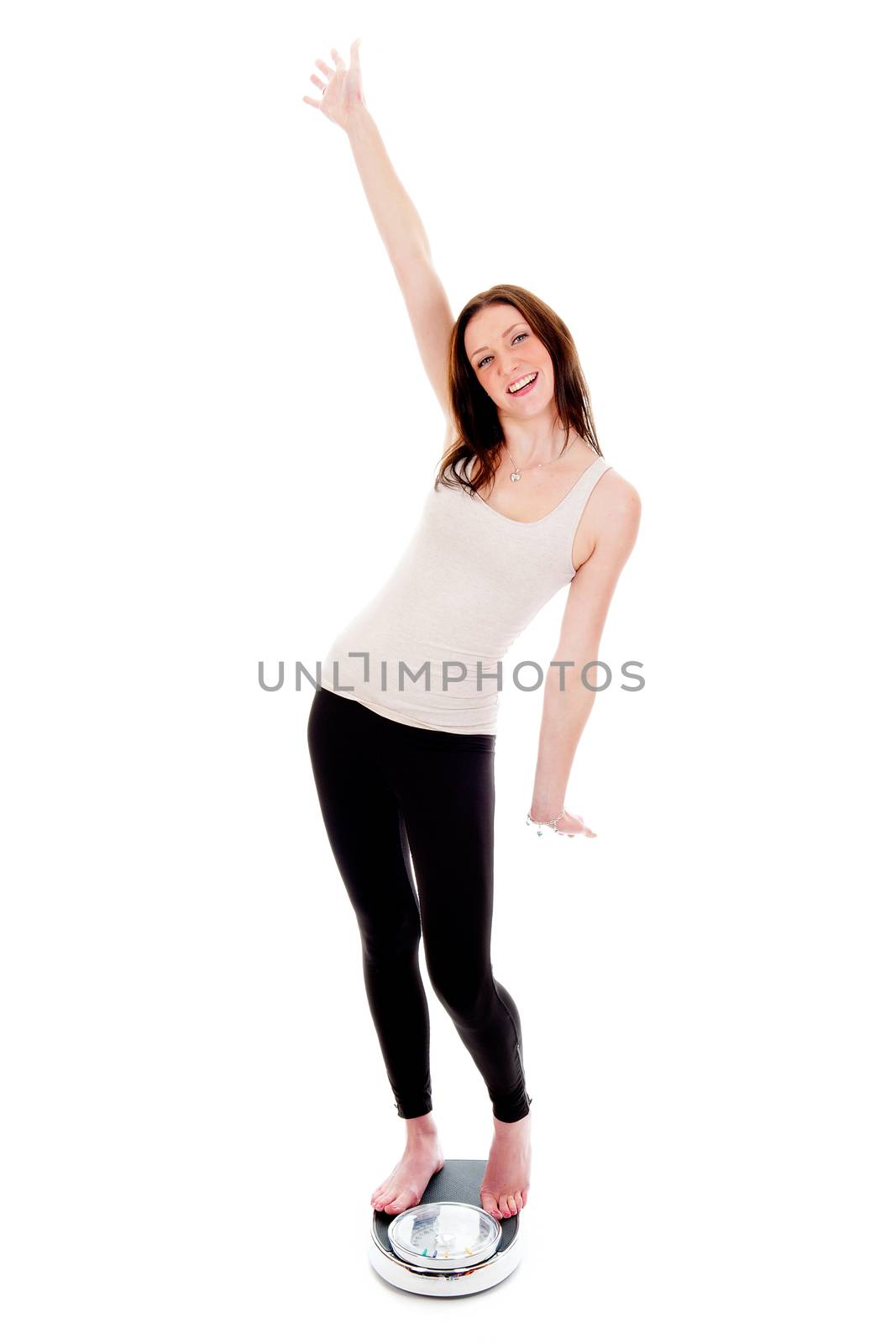 a girl on a weighing scale, celebrating her success of loosing weight