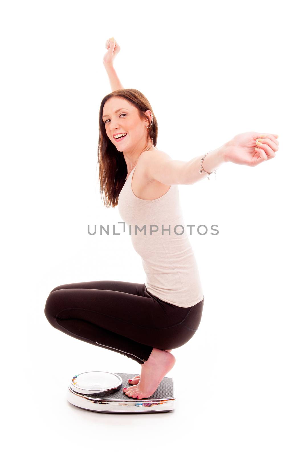 a girl on a weighing scale, celebrating her success of loosing weight