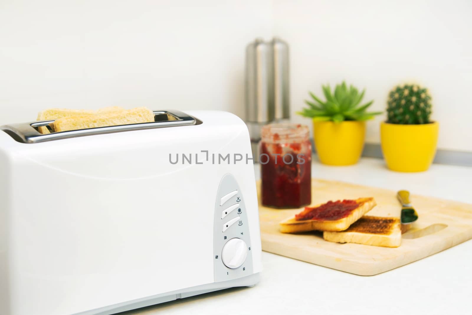 Breakfast prepare. Toaster and toast with jam in modern kitchen by simpson33