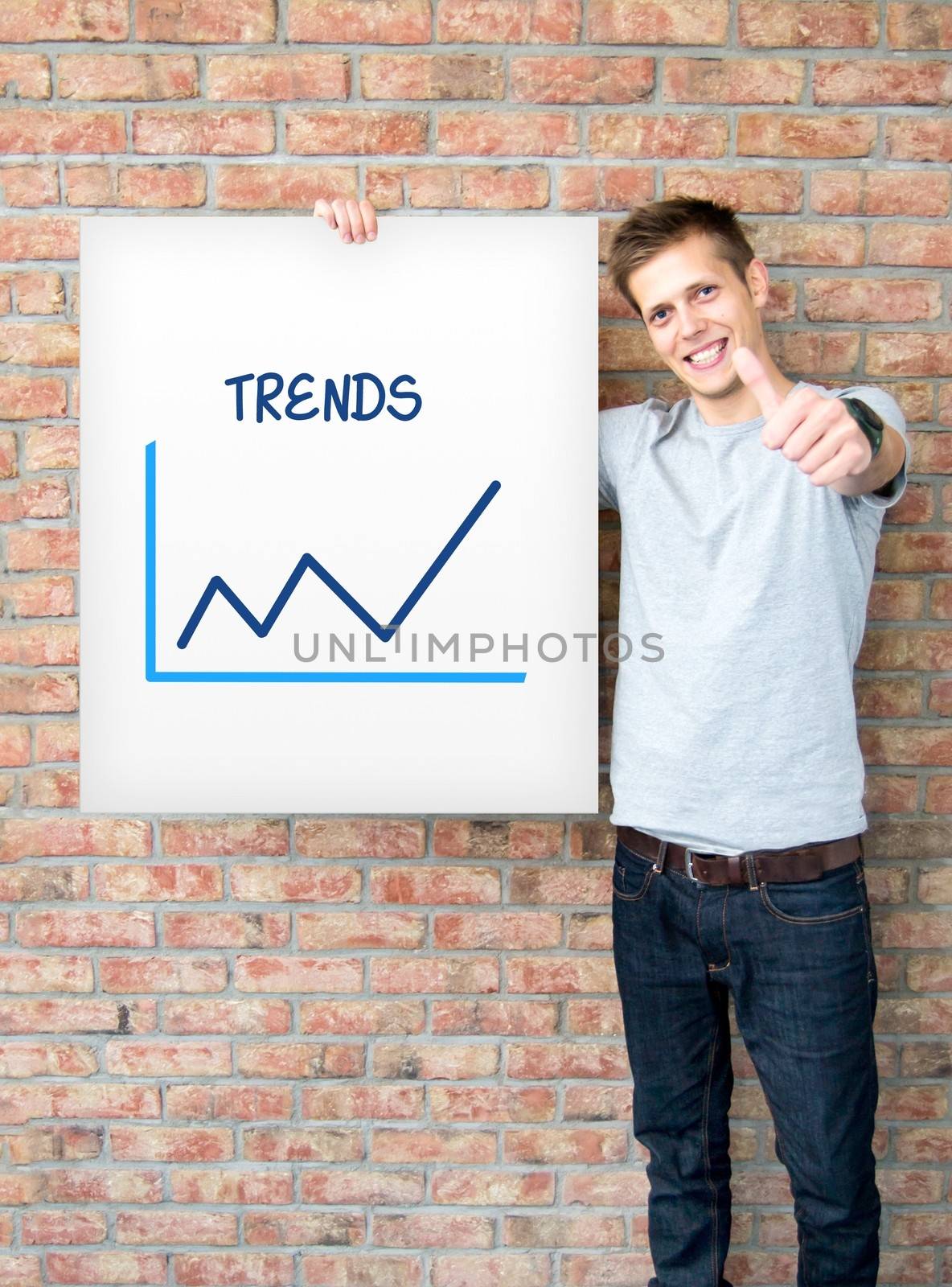 Young man holding whiteboard with trends chart