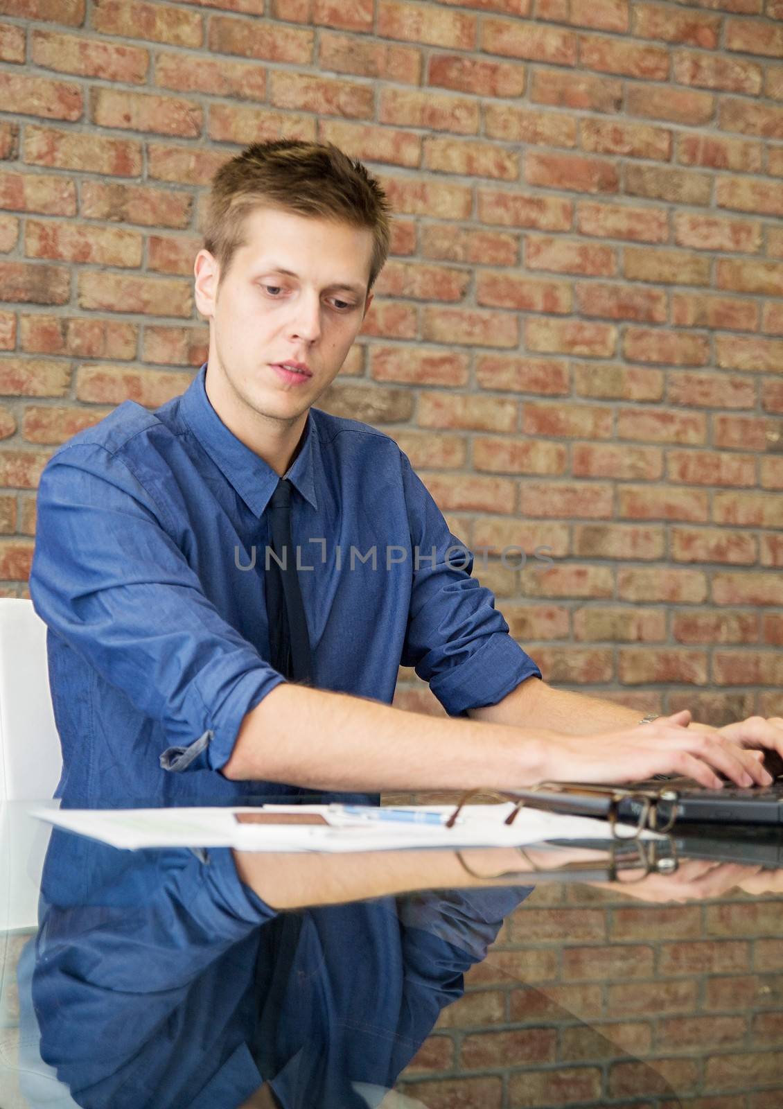 Young businessman sitting at table and working with charts by simpson33