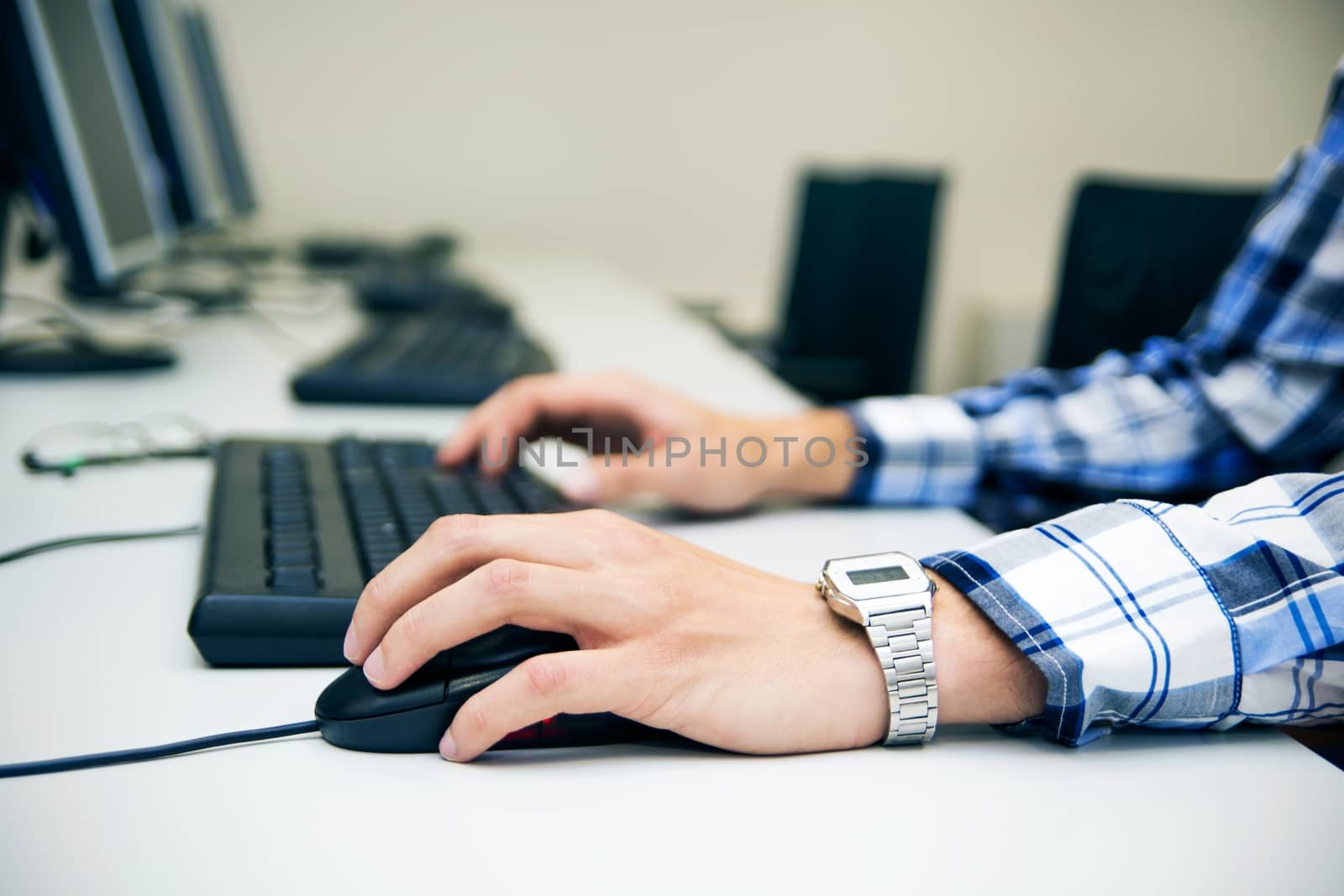 Young man typing on keyboard. Training room with computers by simpson33