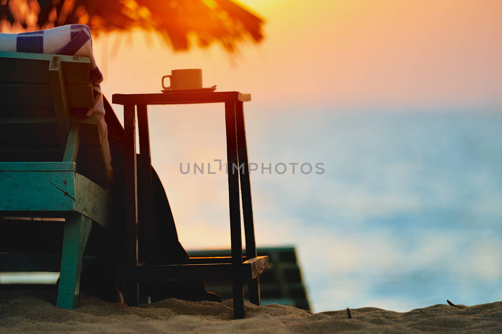 Exotic beach umbrellas and chairs on tropical coast on evening