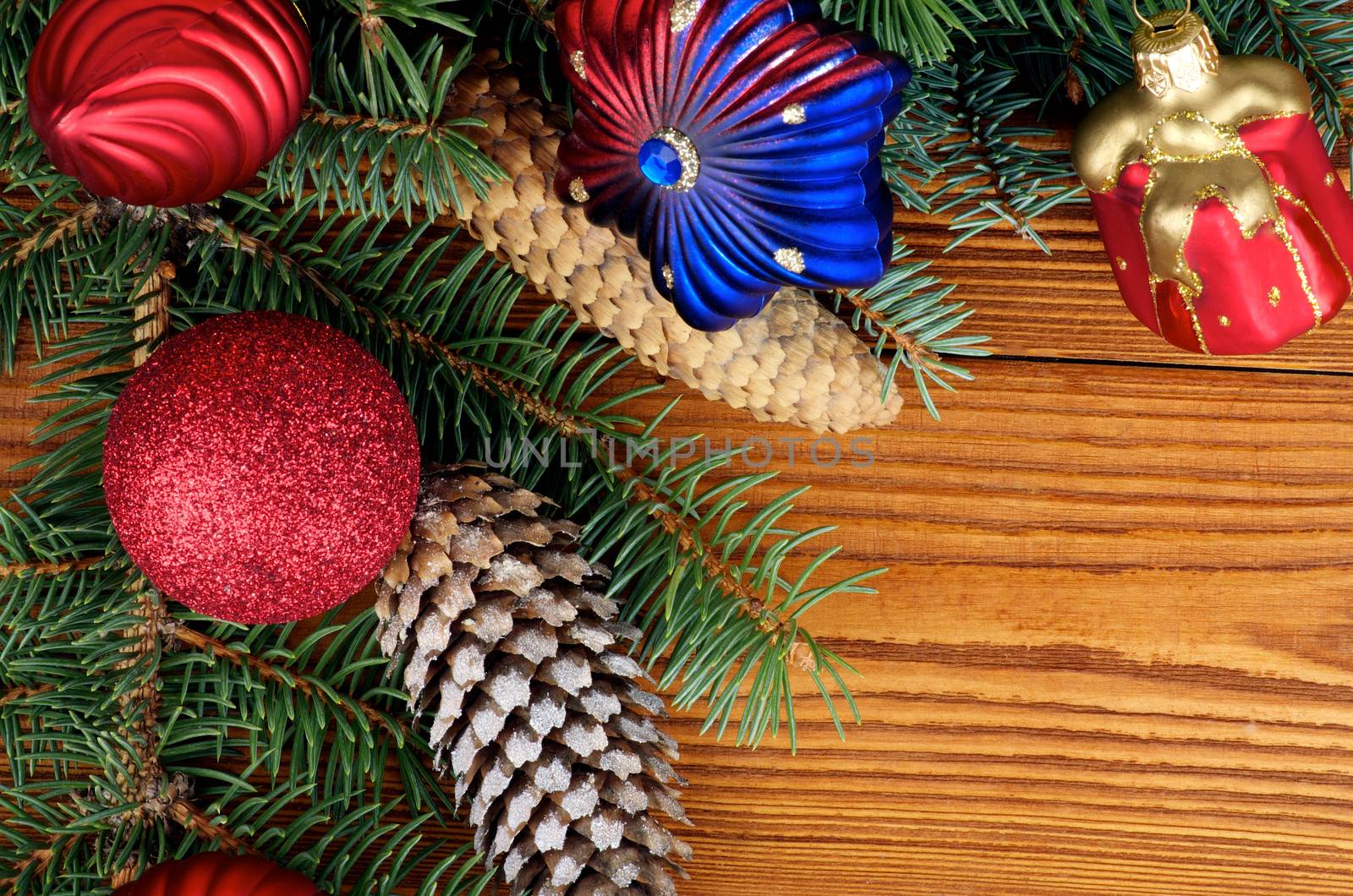 Frame of Christmas Decoration with Spruce Branch, Shape Star, Red Gift Box, Baubles and Fir Cones closeup on Wooden background