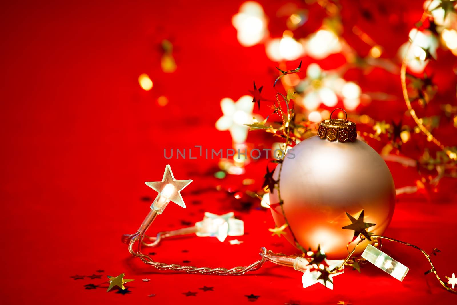 Christmas bauble with star-shaped lights on red background