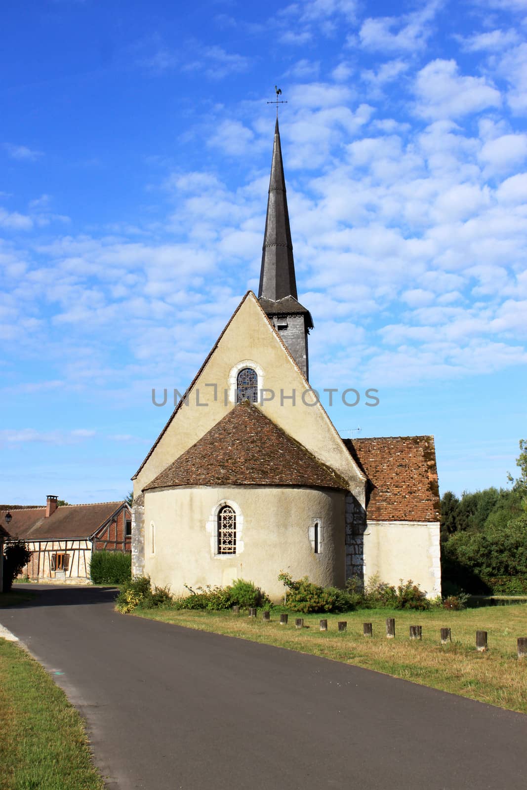 a small religious chapel at the edge of a road near a natural park