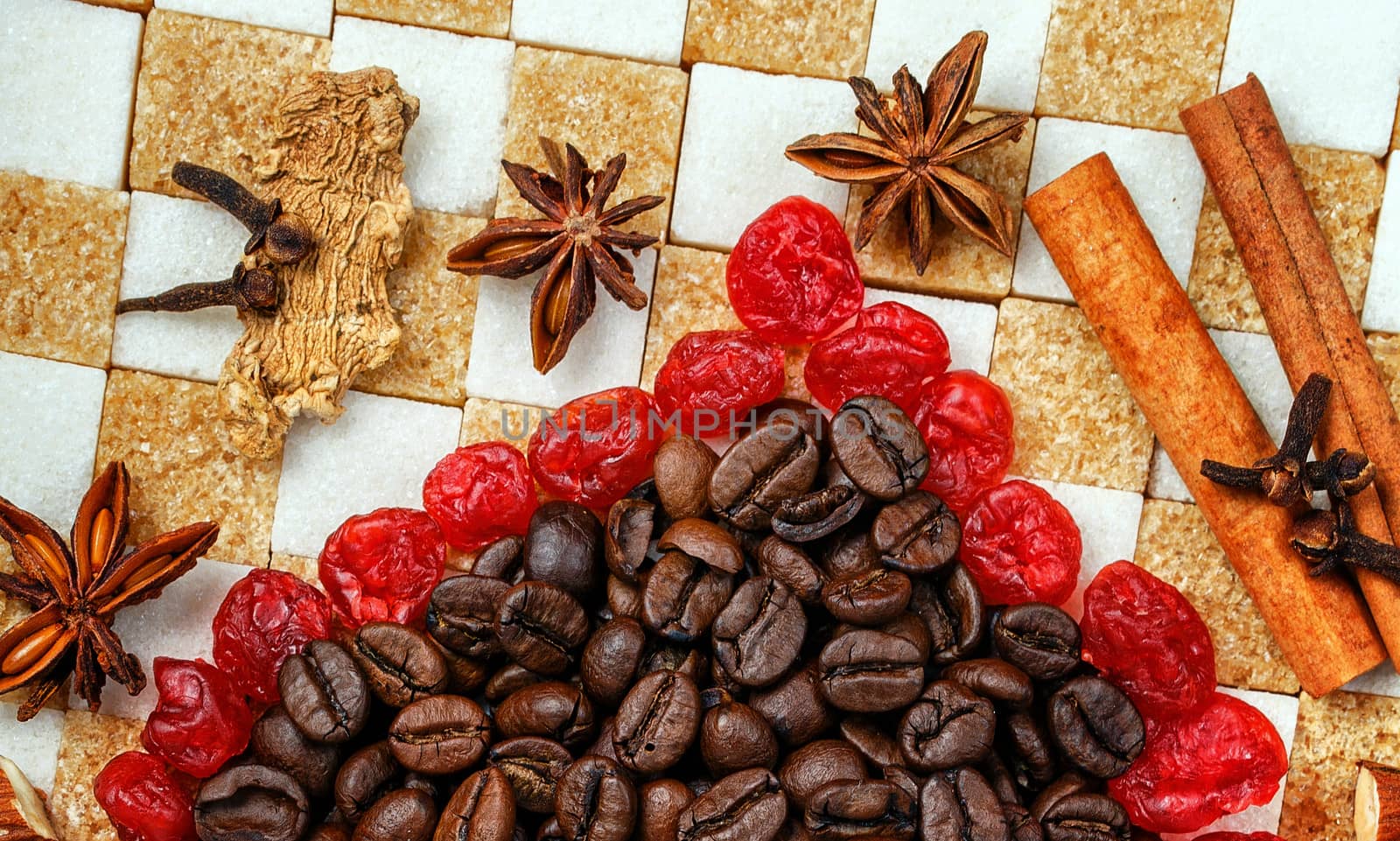 Sweets, spices and coffee beans laid out on a background of refined sugar