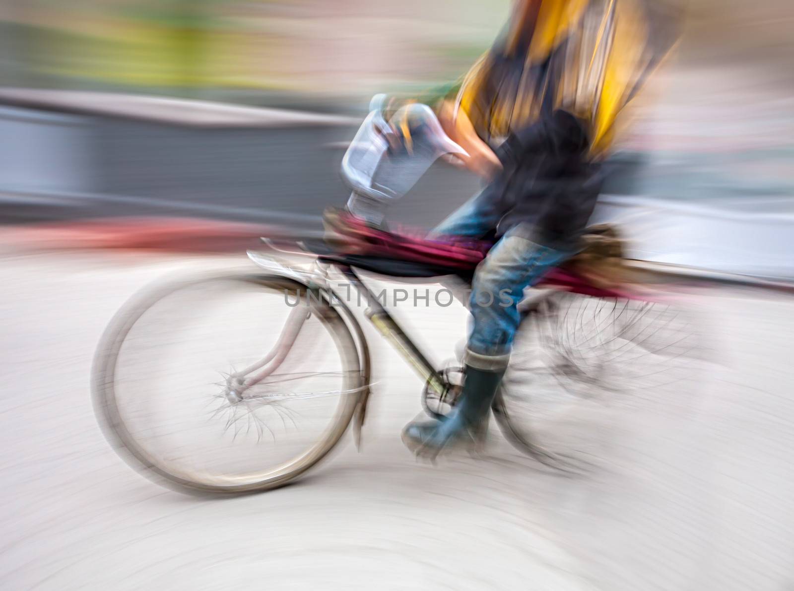 Cyclist in motion blur with blurred urban background