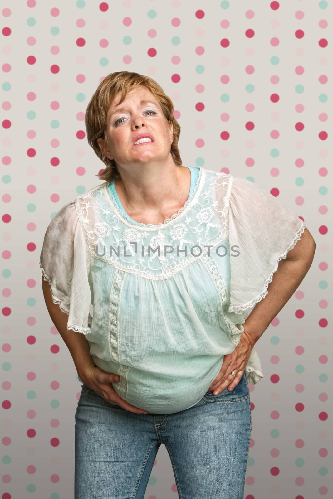Caucasian pregnant woman holding stomach in pain