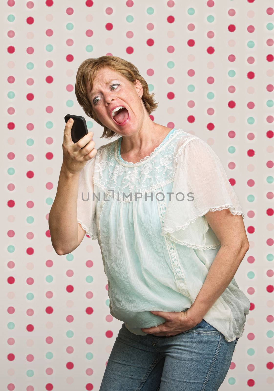 Pregnant woman holding belly while yelling at phone