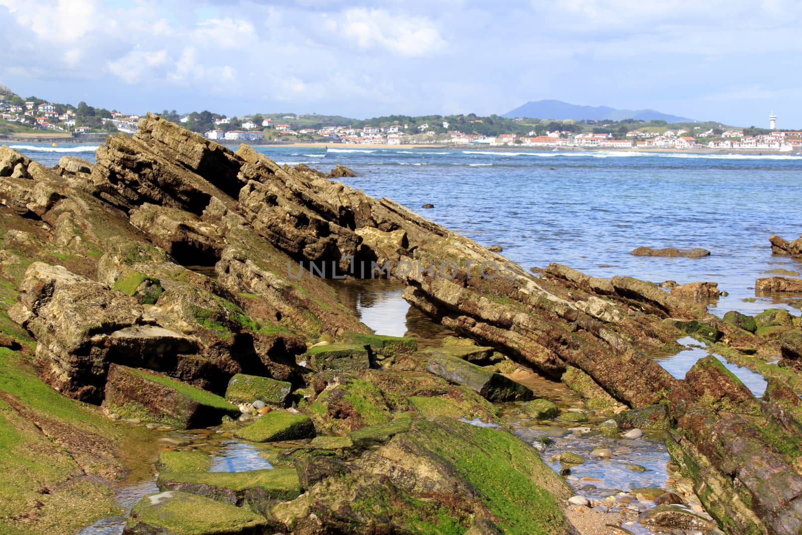 rocks by the sea at low tide on an ocean horizon and mountains