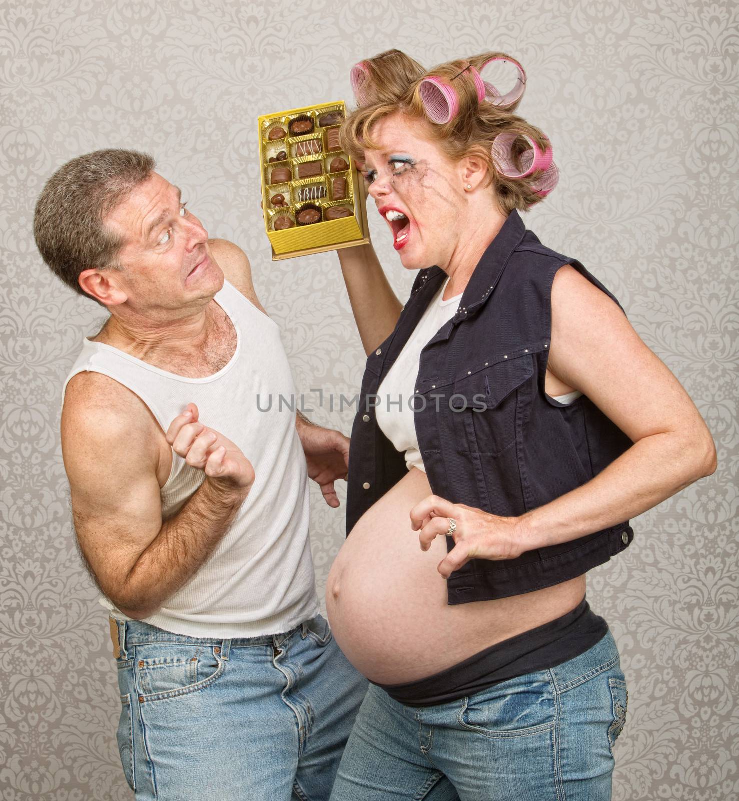 Angry pregnant hillbilly woman yelling at man with chocolate