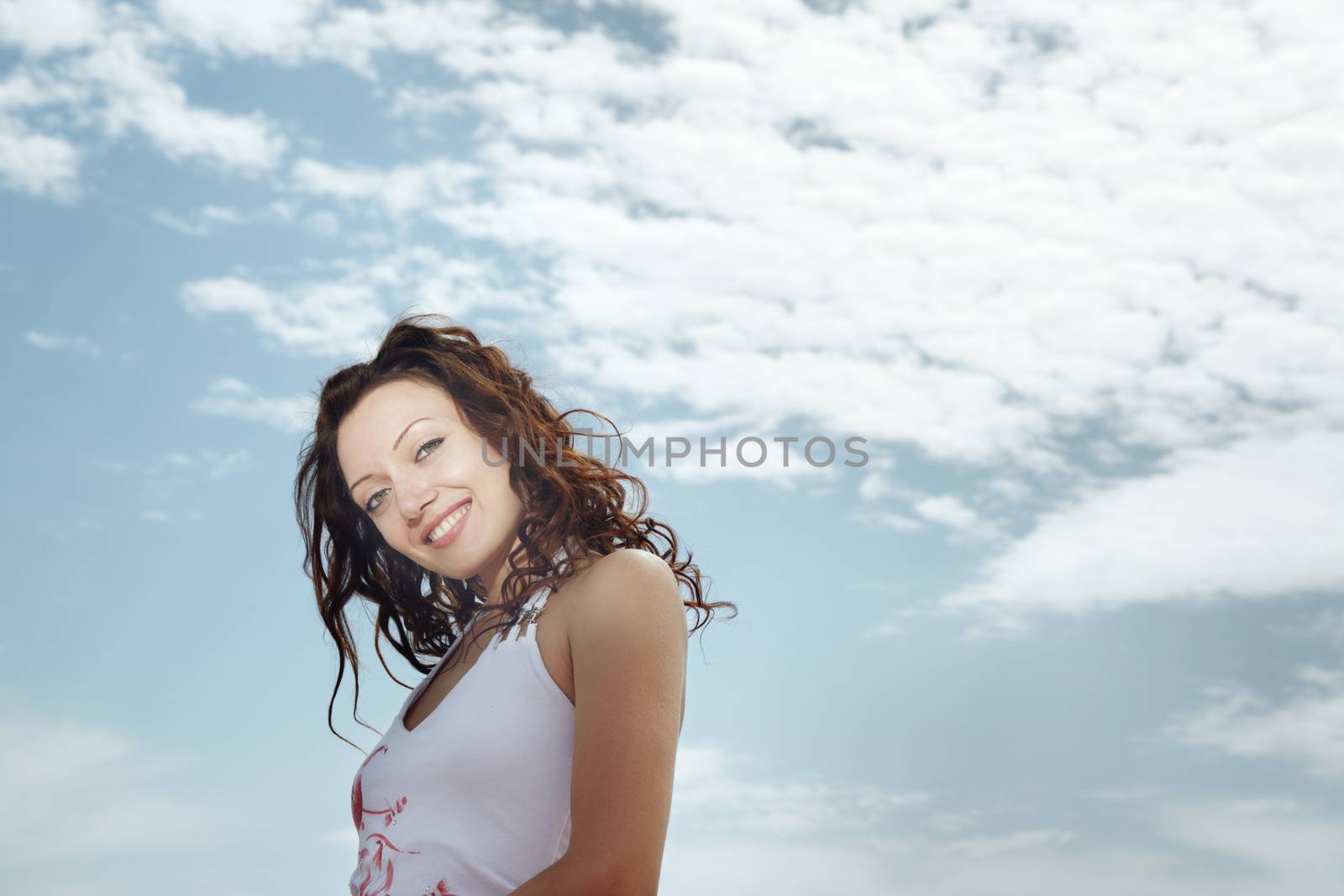 Smiling successful lady outdoors and cloudy sky on the background