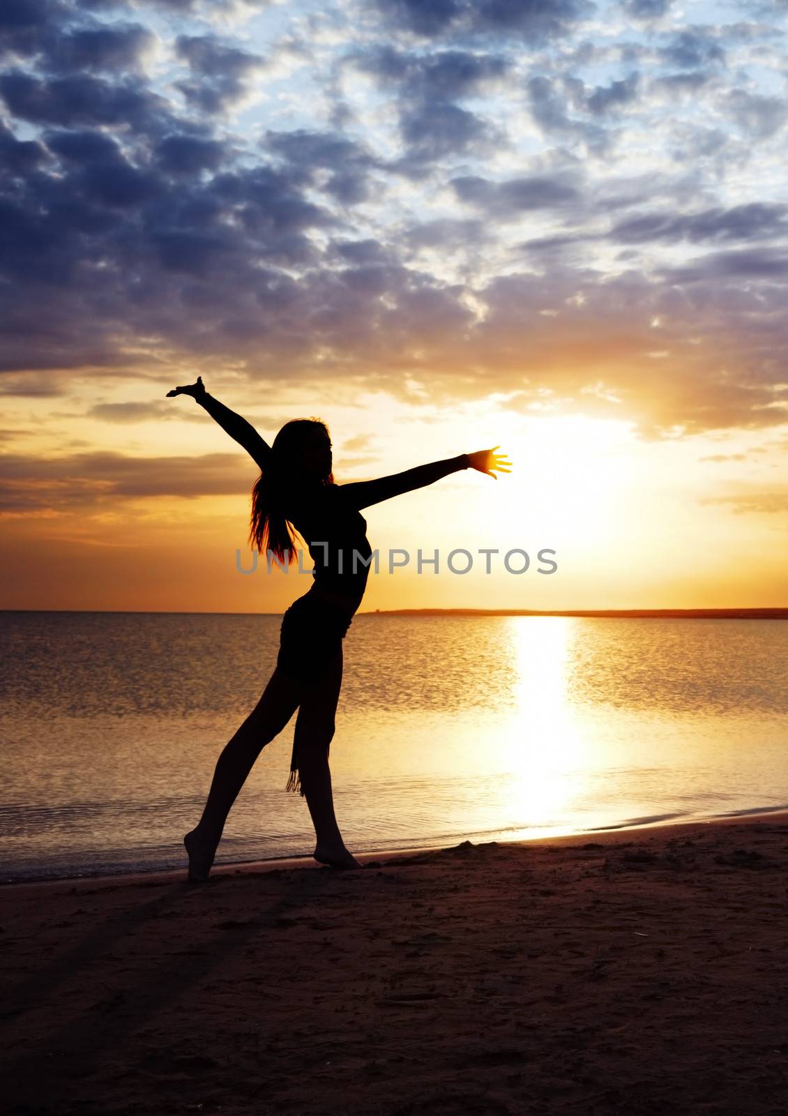 Beautiful sunset and elegant lady making exercise