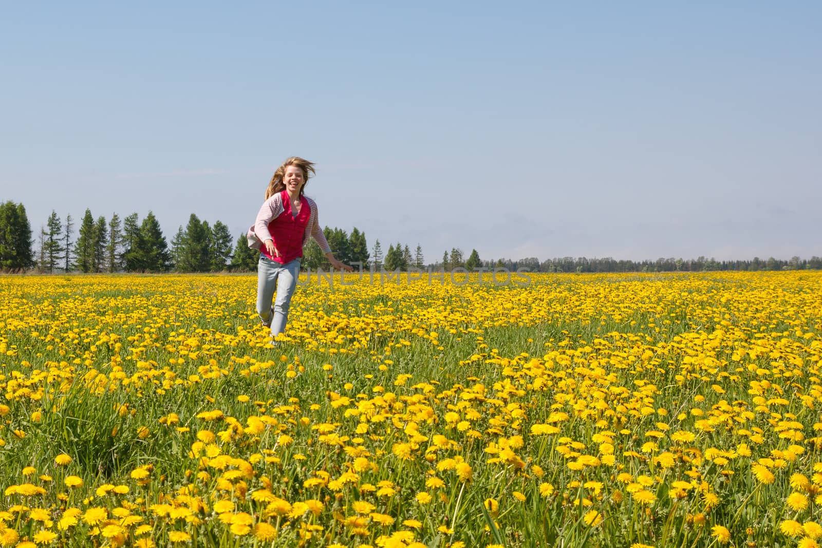 smiling girl run over dandelion meadow