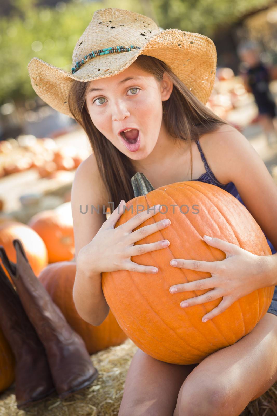 Preteen Girl Holding A Large Pumpkin at the Pumpkin Patch
 by Feverpitched