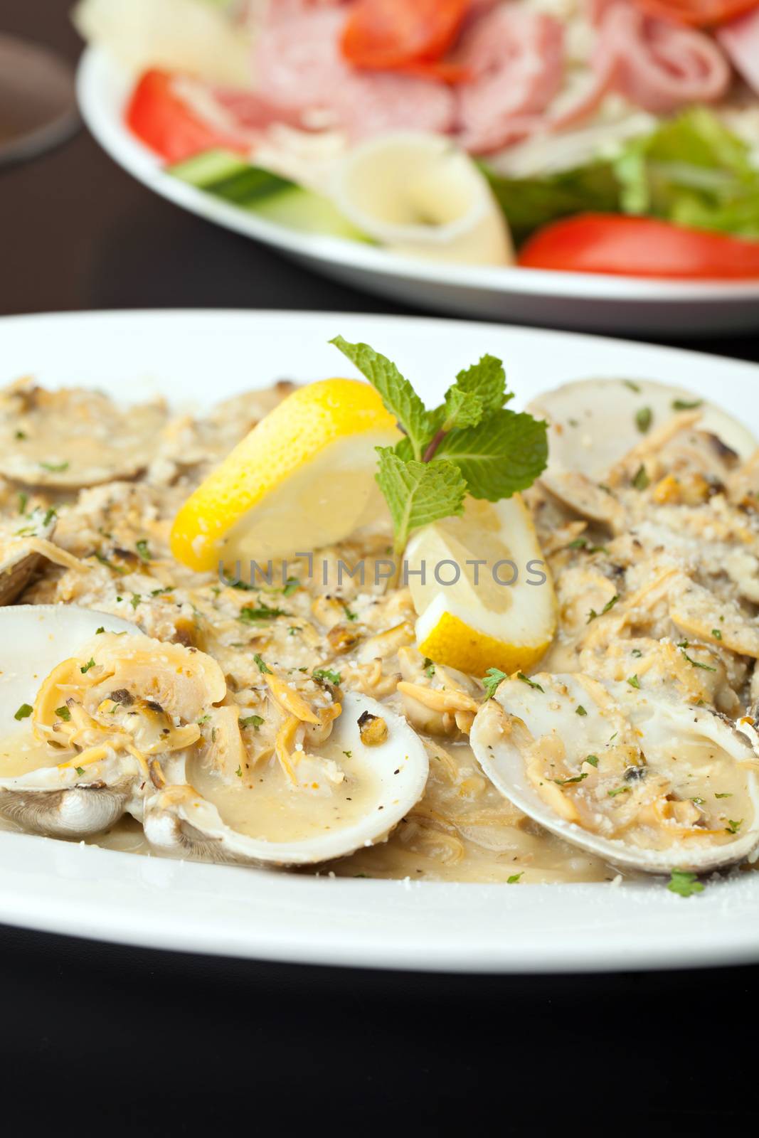 Italian pasta dish with fresh clams over pasta with herbs and cheese.  Shallow depth of field.