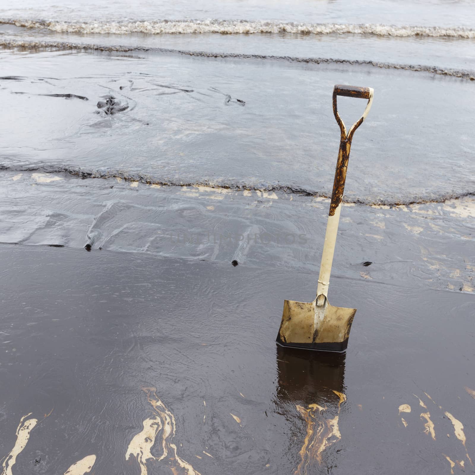 A Spade on dirty beach as tool to scoop crude oil on clean-up operation from crude oil spilled into Ao Prao Beach on July 31, 2013 in Rayong province, Thailand.