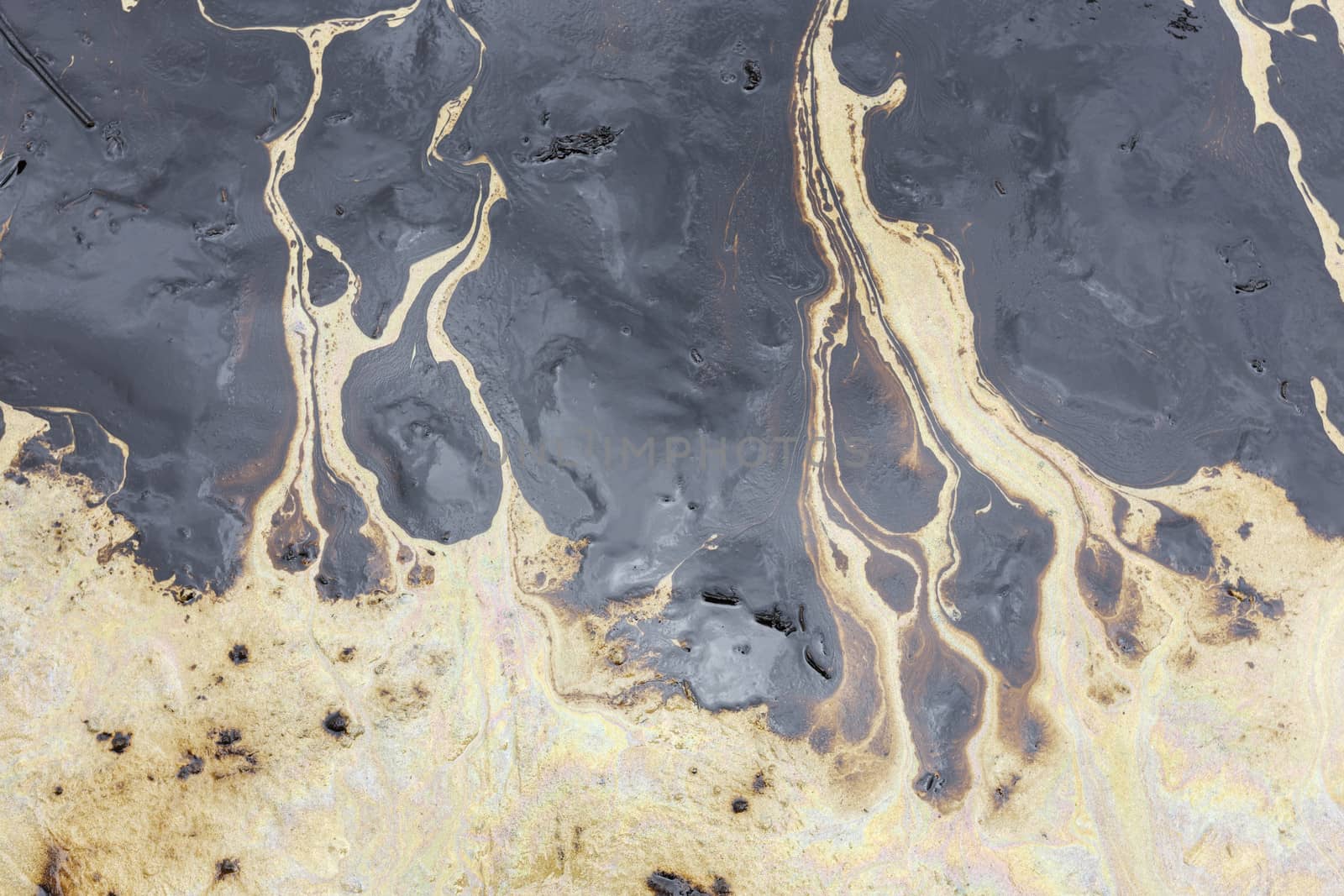 Texture of Crude oil spill on sand beach.