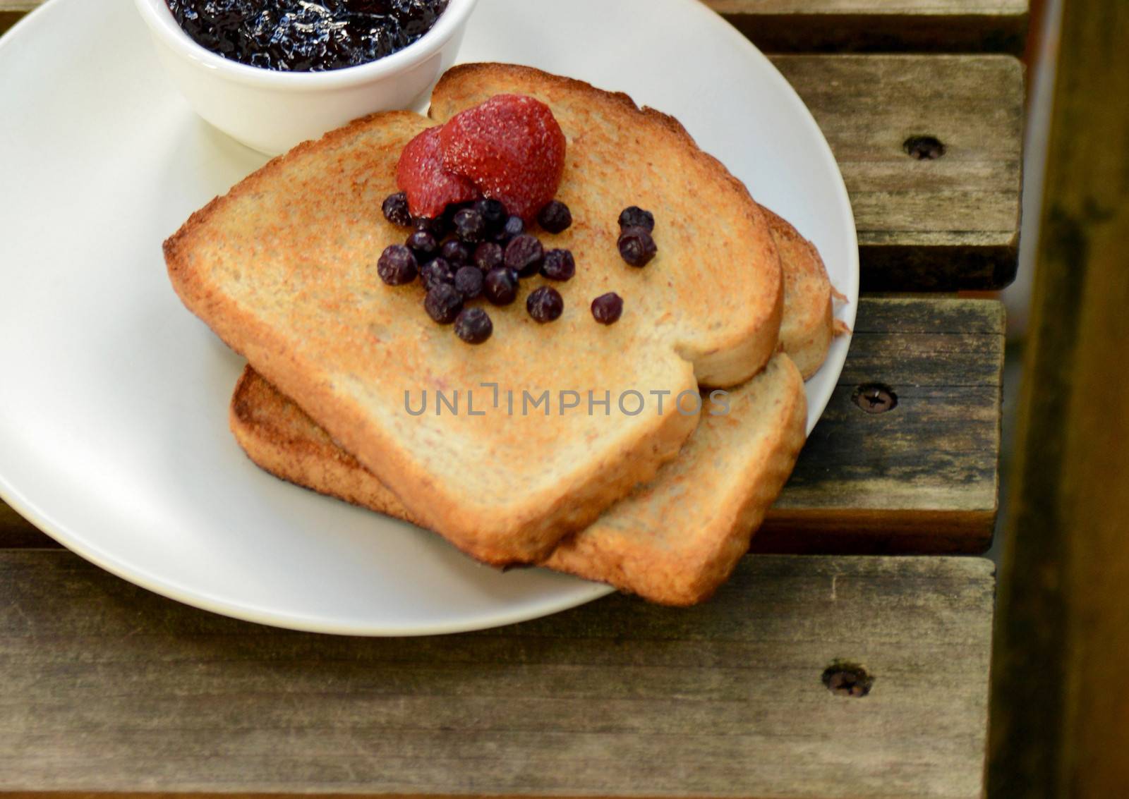 strawberry and blueberry toast with wooden background