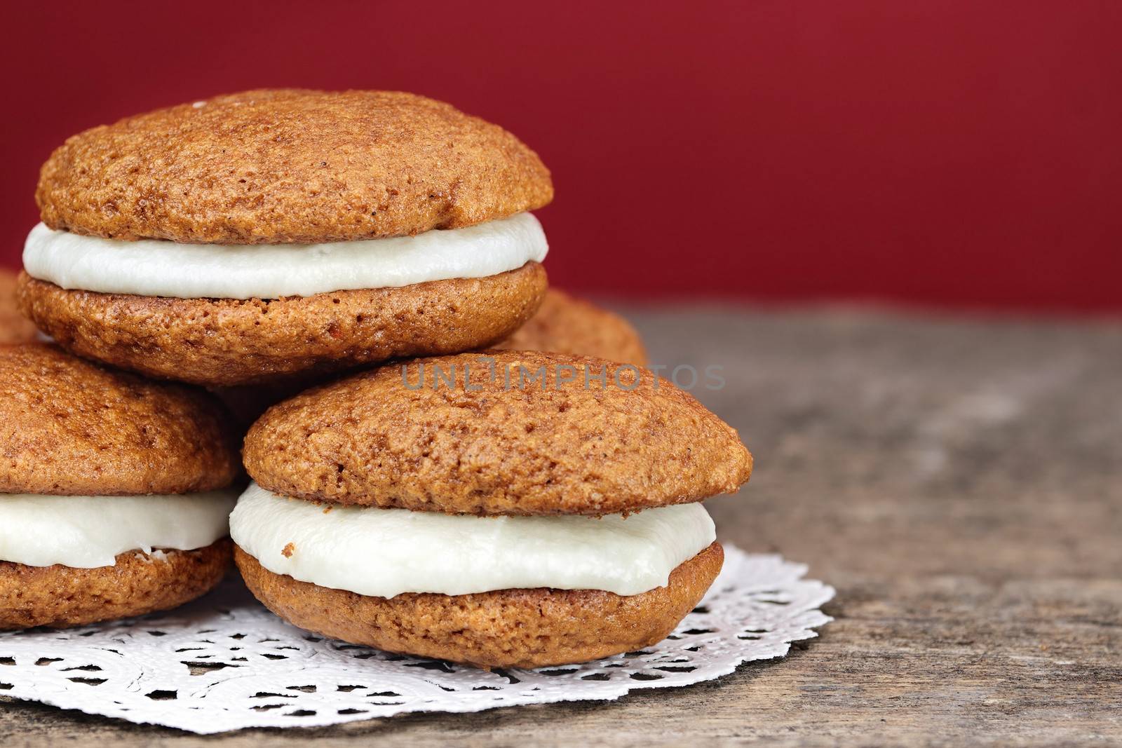 Stack of homemade Pumpkin Whoopie Pies or Moon Pies made with cream cheese frosting. 