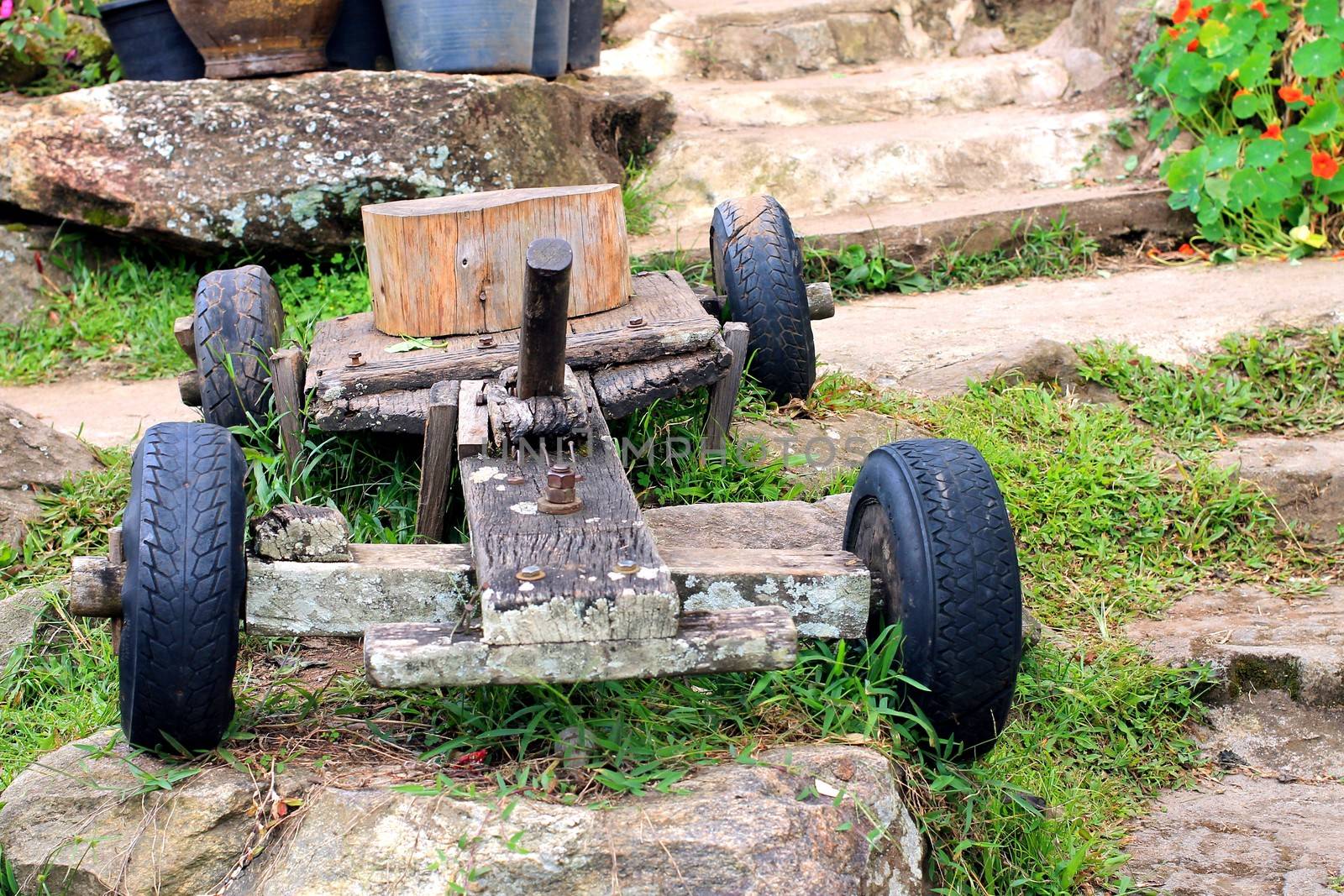 Old wooden rustic toy car on a garden background