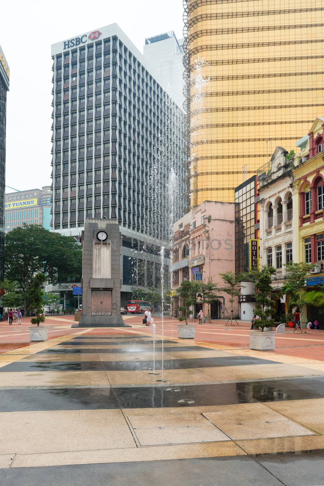 KUALA LUMPUR - JUNE 22: Fountain and clock tower on old market square on June 22, 2013 in Kuala Lumpur, Malaysia. The clock tower was erected in 1937 to commemorate the coronation of King George VI. 