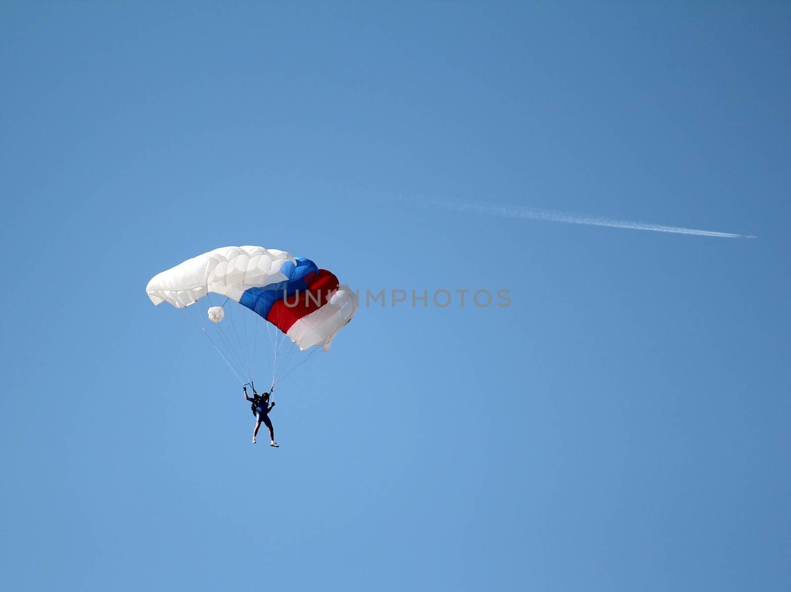 parachutist and airplane on blue sky