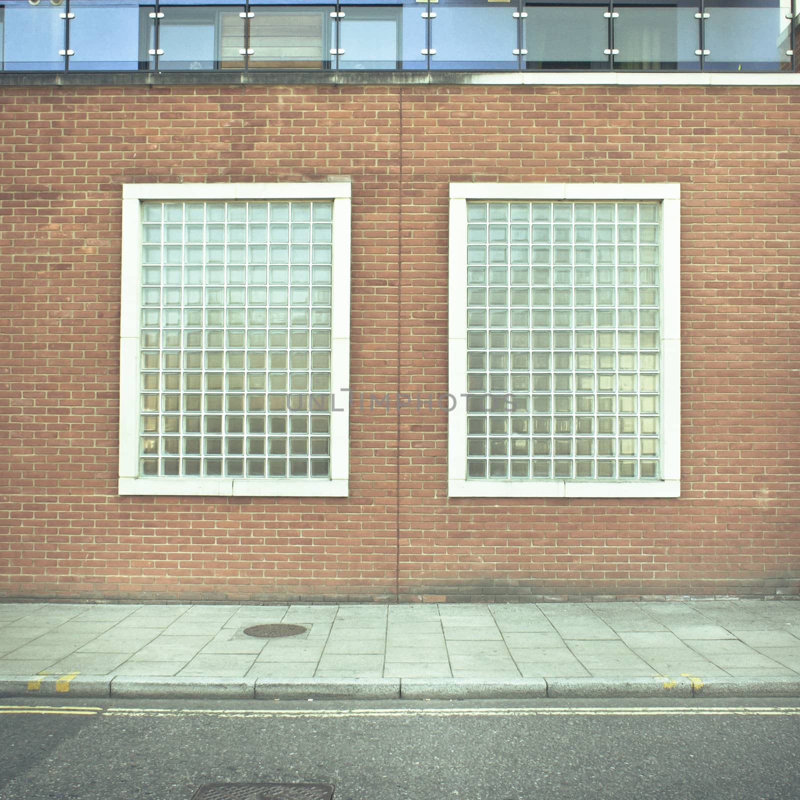 Two glass brick windows in a wall of an urban building