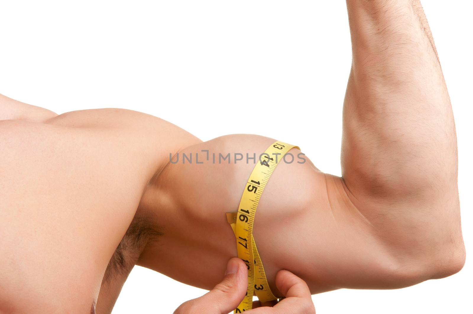 Fit man measures his bicep with a yellow tape, isolated in white