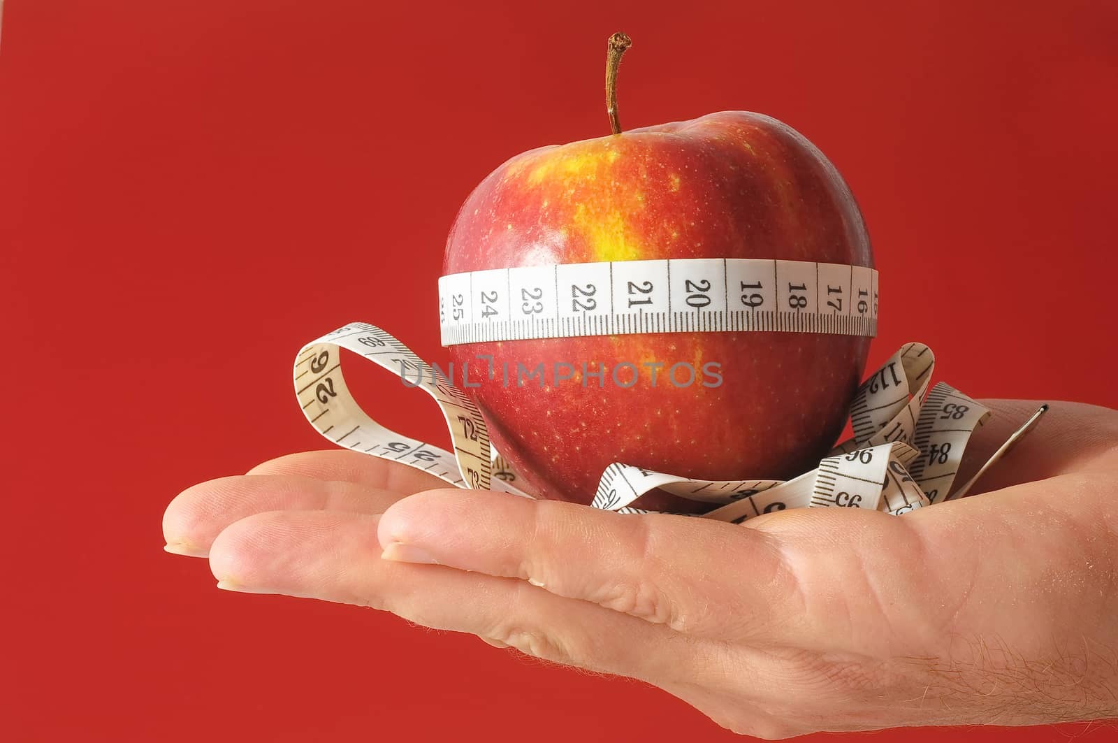 Diet Apple and Meter on the Hand on a Colored Background 