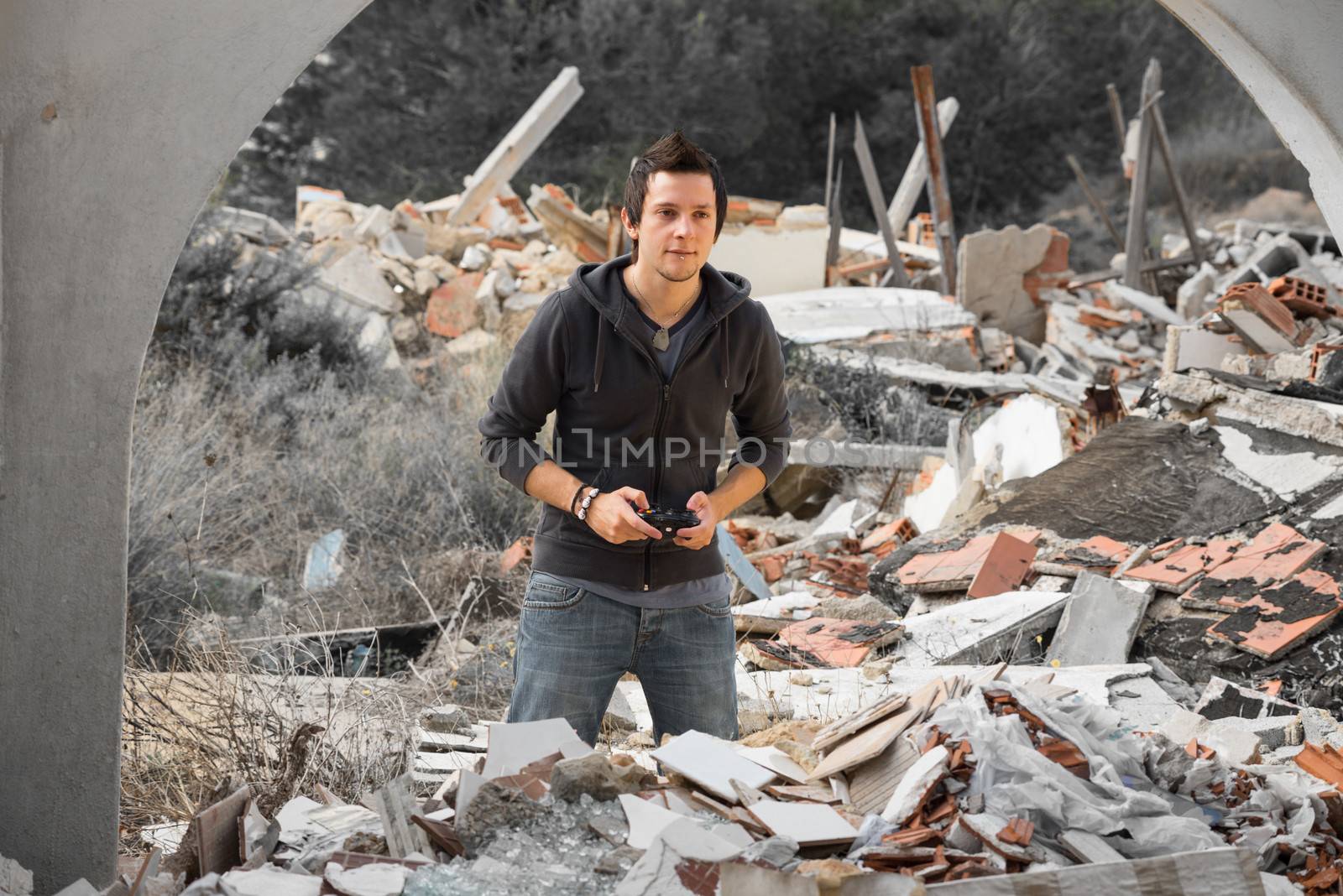 A young guy gaming amidst piles of rubble, a modern life concept