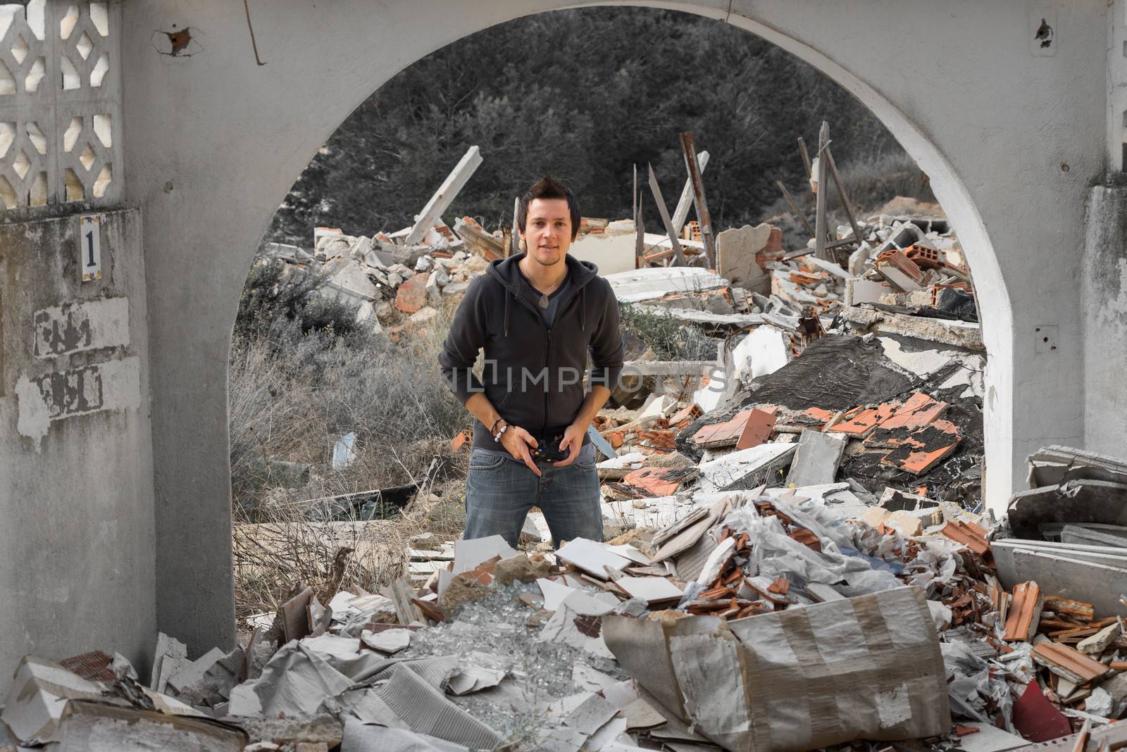 A young guy gaming amidst piles of rubble, a modern life concept