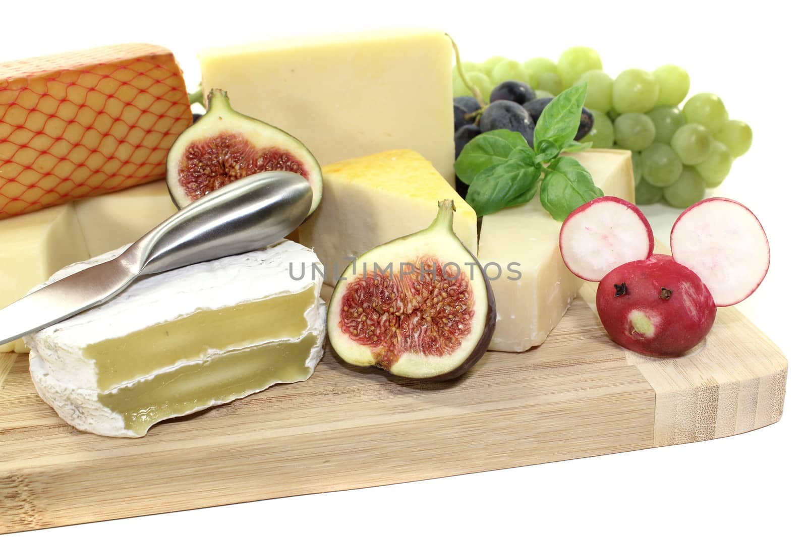 fresh selection of cheese with knife, grapes and figs