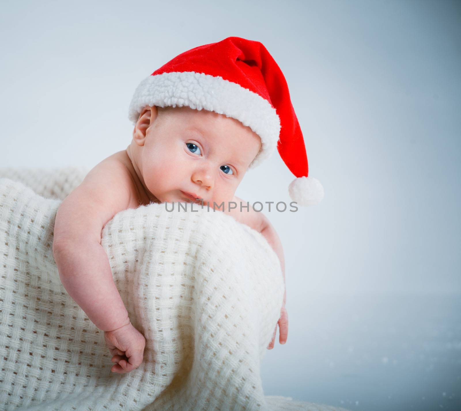 Christmas theme. A baby boy in a Santa suit in studio