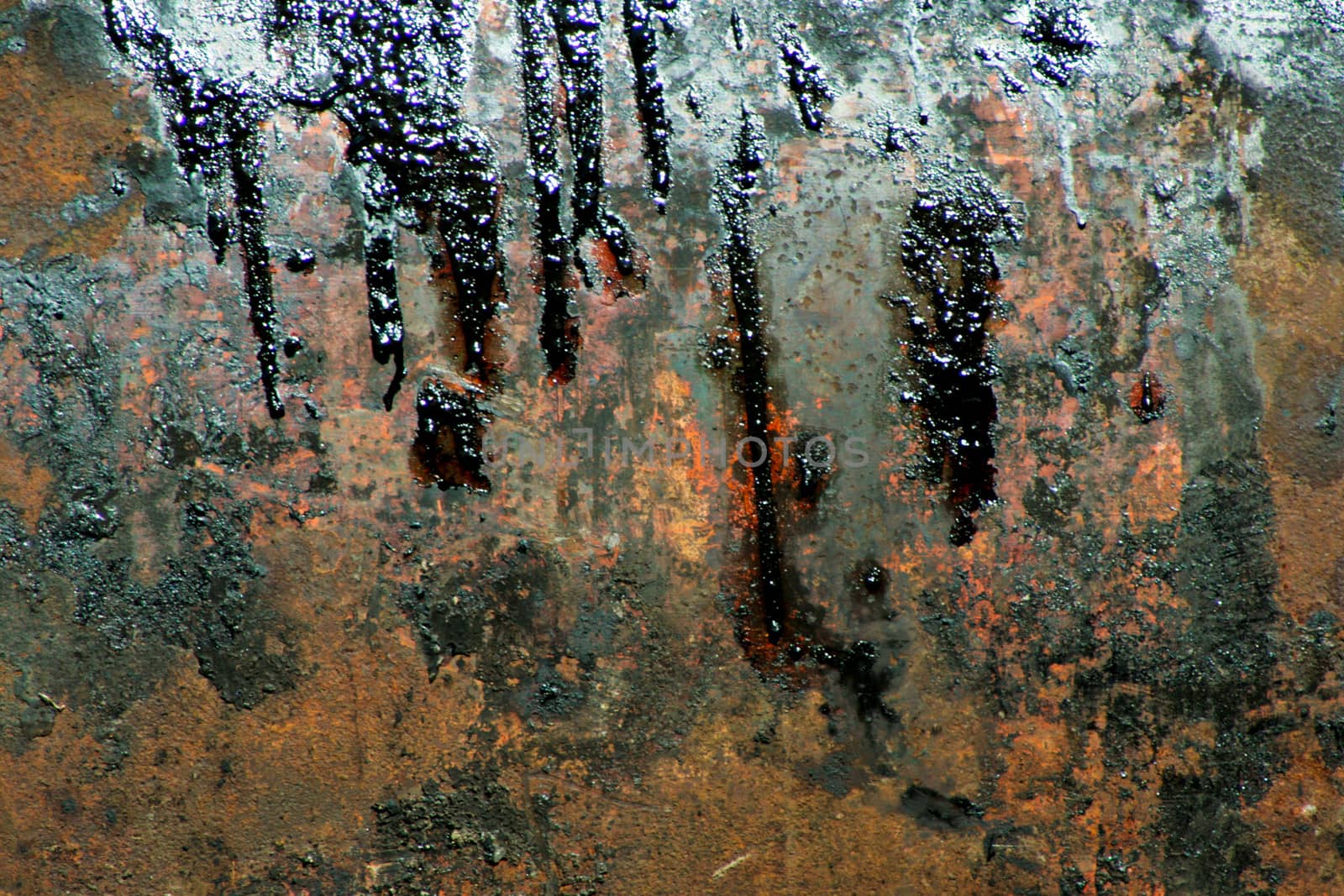 Rusted metal with oil stains.