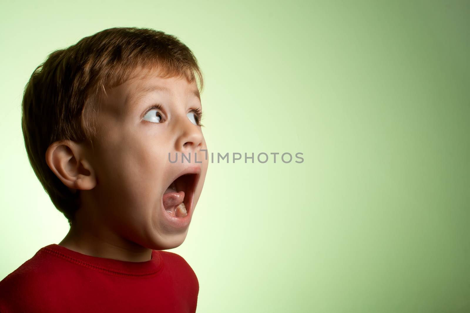 Little blond boy making scared face.