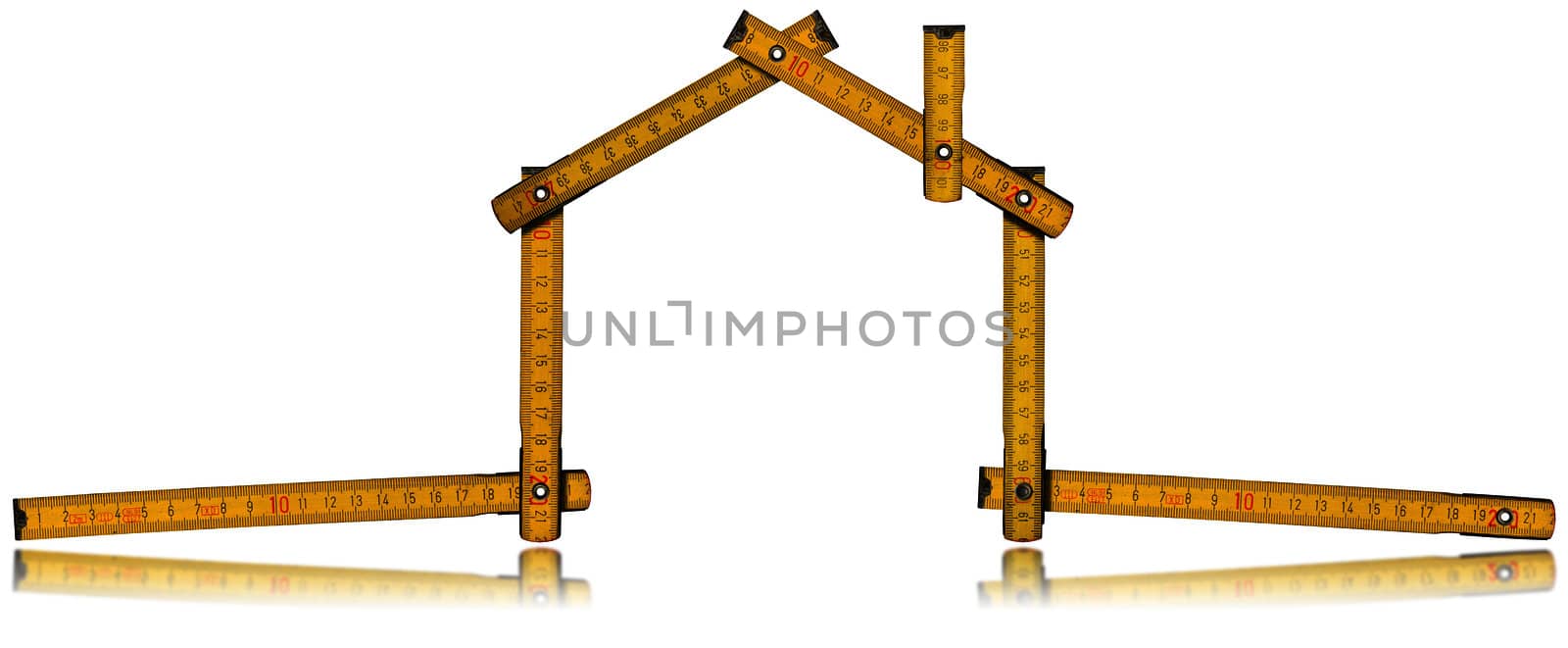 Wooden yellow meter tool forming a house with reflection on white background
