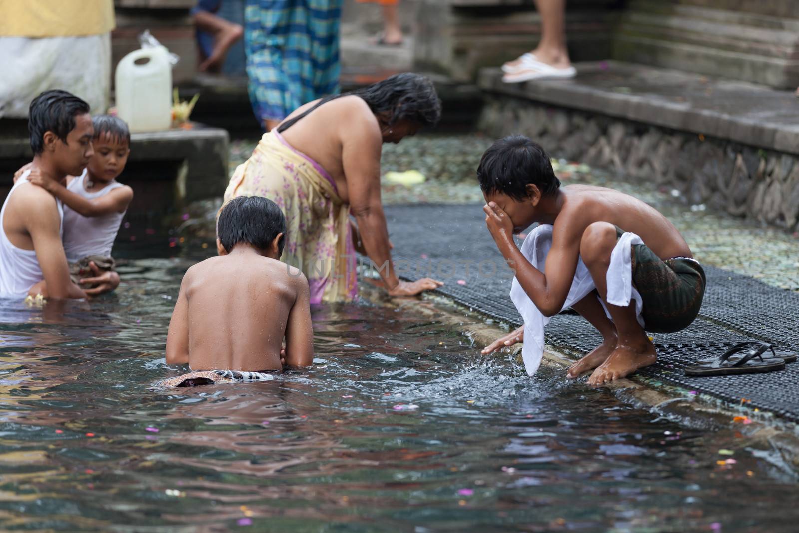 TIRTA EMPUL, INDONESIA - SEP 21: Bali prayers take a bath  in the sacred holy spring water on Sep 21, 2012 in Tirta Empul, Bali, Indonesia. It is famous place for purification of Bali people