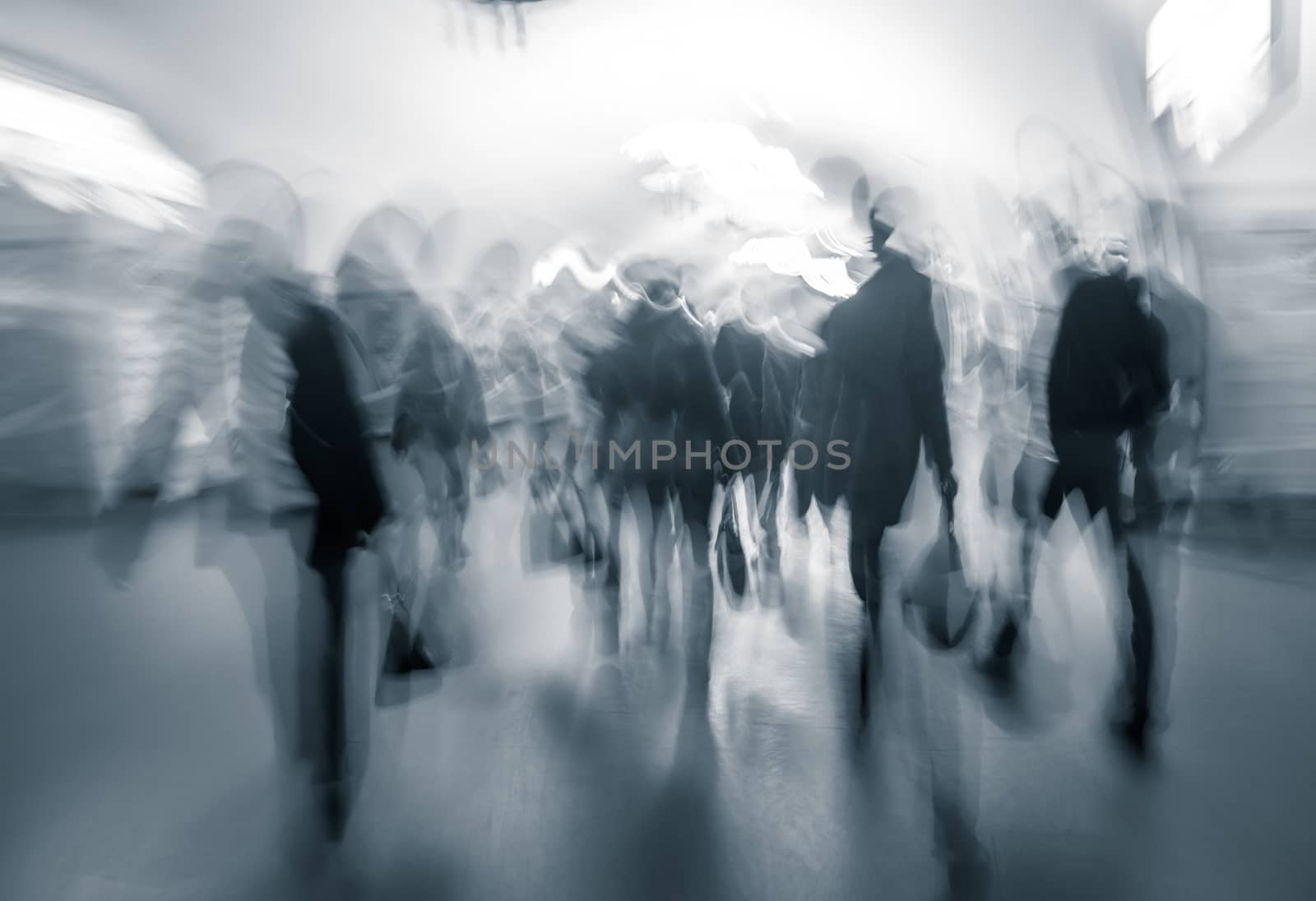Human traffic in the lobby of the underground at rush hour. Intentional motion blur and a blue tonality