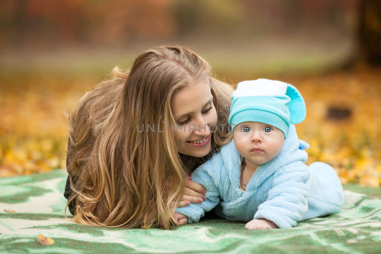 Young woman with baby boy in autumn park