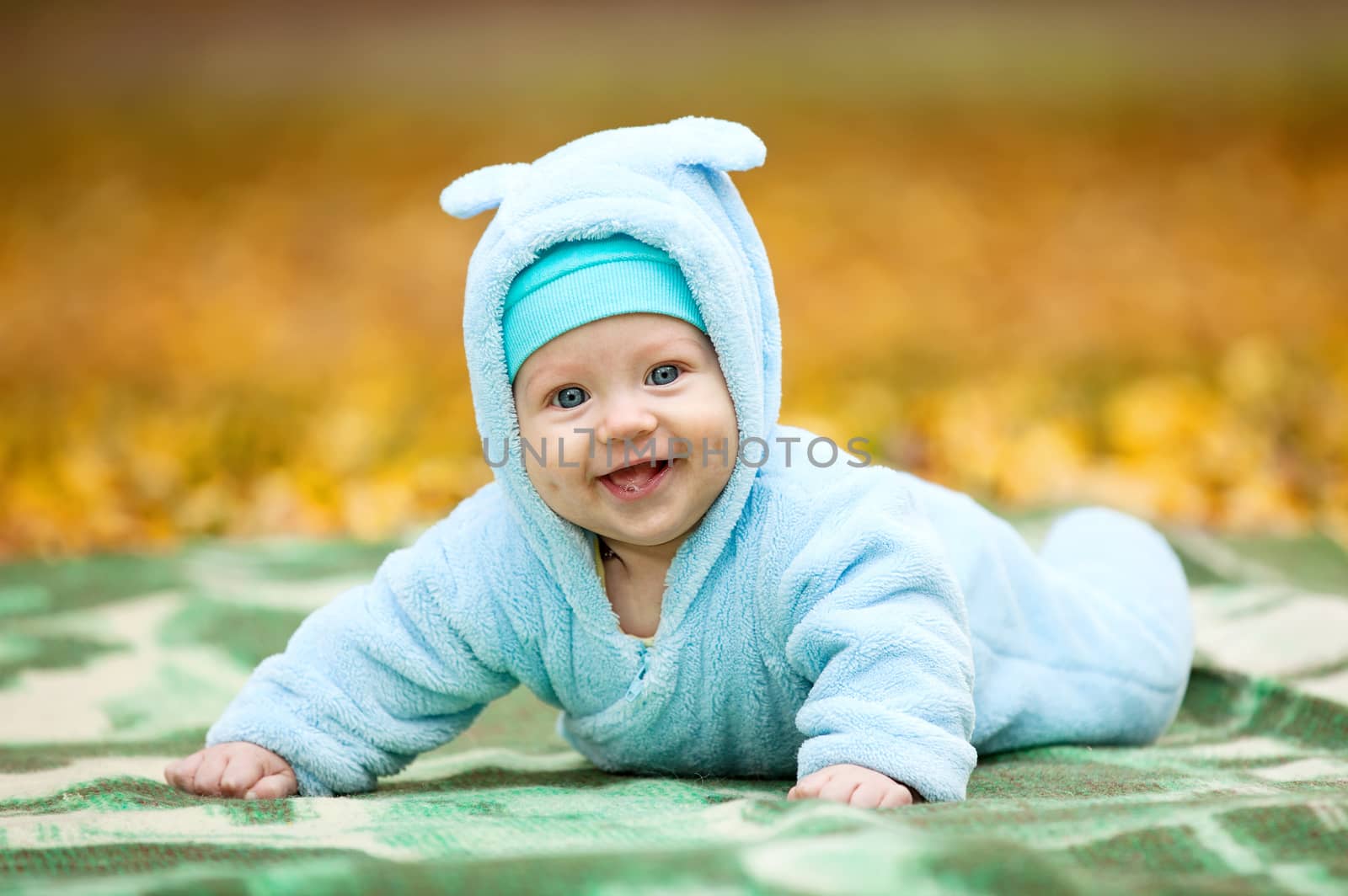 Happy baby boy in autumn park by photobac