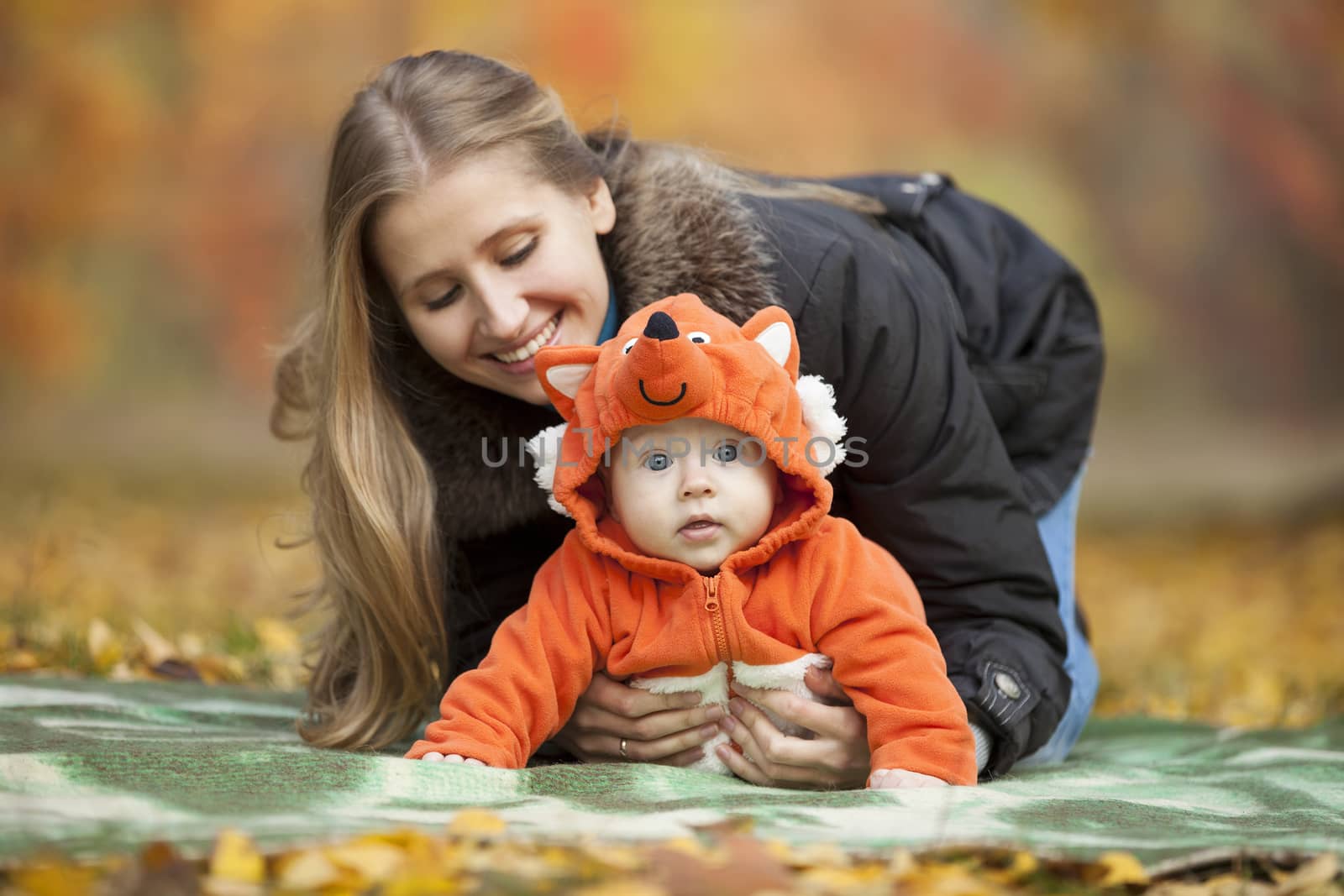 Young woman with baby dressed in fox costume by photobac